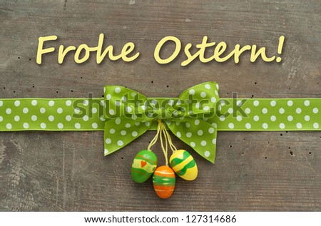 Card with dotted green loop and easter eggs on wooden ground/easter/card