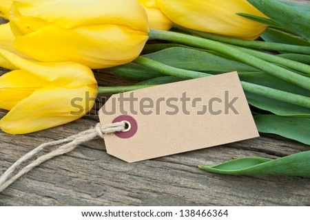 yellow tulips,  and label on wooden ground/tulips/flowers