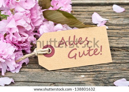 pink blossoms and label with lettering  all the best/flowers/all the best