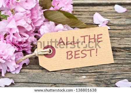 pink blossoms and label with lettering  all the best/flowers/all the best