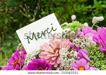 pink flowers and card with lettering thank you/thank you/french