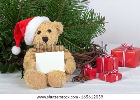 Teddy bear with santa hat, gifts and white card/christmas/teddy bear