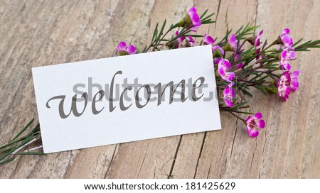 welcome card with pink flowers on a wooden board/welcome/english
