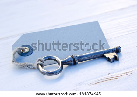 Old key and card on white wood/old key/label