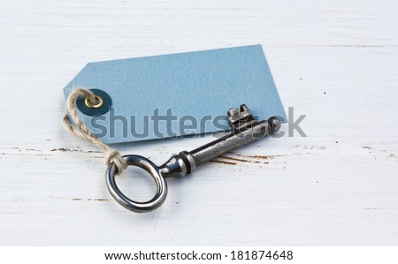 Old key and card on white wood/old key/label