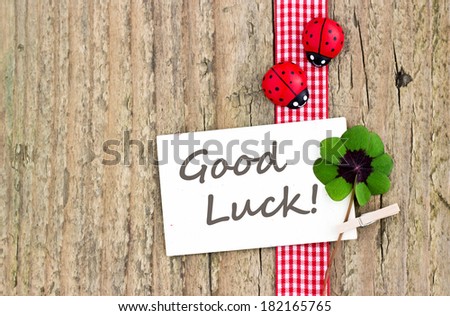 Leafed clover, ladybugs and card on wooden board/good luck/english