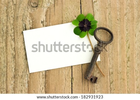 White card with key and clover  on  board/key and clover/luck