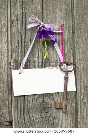Bunch of violet flowers, key and card on a wooden board/key/bouquet