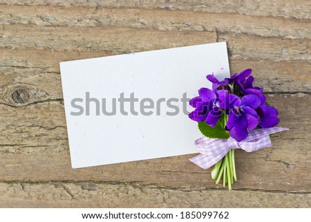 Bunch of violets and card on a wooden board/violets/bouquet