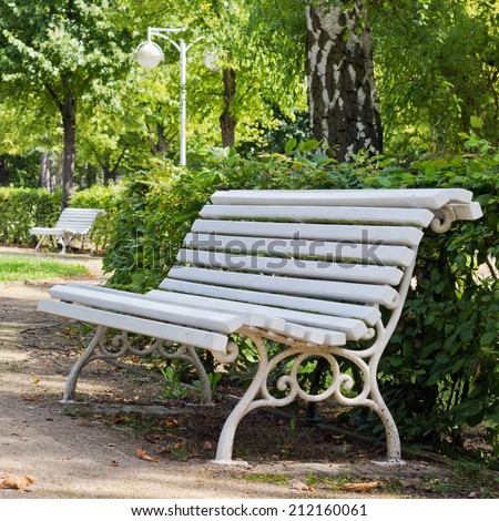 white wooden bench in the park with beech hedge/park bench/break