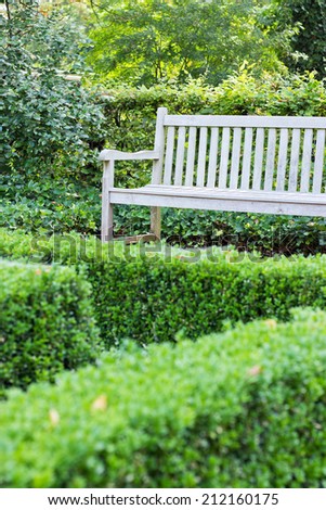 Wooden bench in the park with boxwood hedge/park bench/break