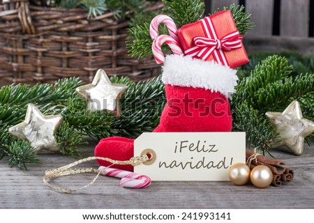 spanish christmas card with red sock, gifts, Candy canes and text merry christmas/merry christmas/spanish