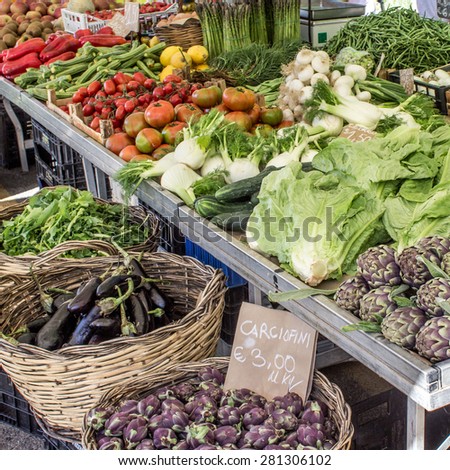 Vegetable stand with artichokes, tomatoes, peppers, lima beans, lettuce, onions, lemons, asparagus and eggplant / vegetable stand / vegetable