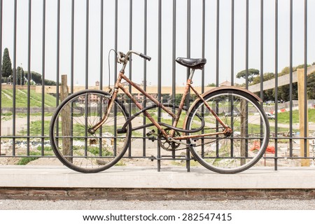 Old, rusted bicycle is a bicycle lock connected to a bridge railing / rusted bicycle / Time