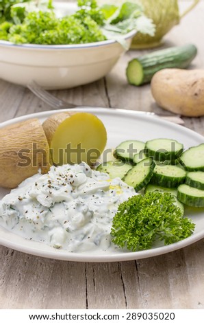 Plate with boiled potatoes, cream cheese, cucumber and linseed oil / Boiled potatoes with herb quark / healthy eating