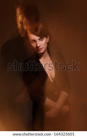 Portrait of strong woman with male shadow behind her