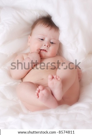 beautiful baby boy on white bed-sheet