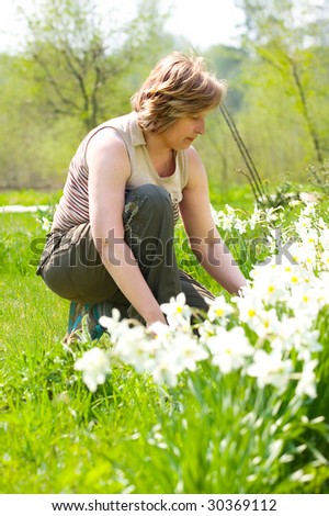 senior woman works with flowers in the garden