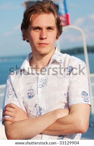 portrait of young man in white t-short on sky background