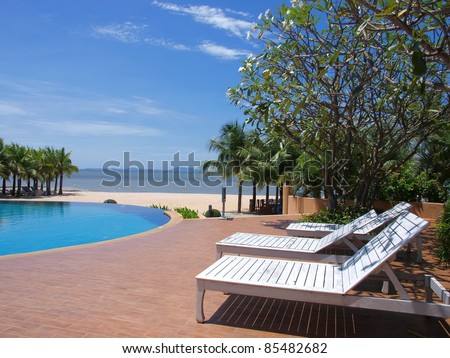 chairs around swimming pool near the beach