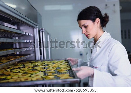 Smiling female engineer in front of food dryer dehydrator machine
