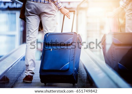 Traveler with luggage on moving walkway.Travel concept.