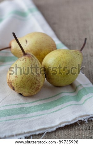Three pears on hessian and a rustic mat