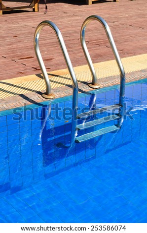 Blue swimming pool with metal ladder