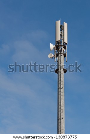 Telecommunication mast with microwave link antennas over a blue sky