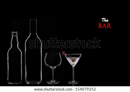 Bar Concept with a Beer Bottle, a Wine Bottle, a Wine Glass and a Cocktail in a Martini Glass on a Black Background. Copy Space.