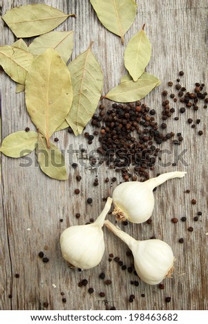 Garlic, pepper and bay leaf Garlic, black pepper and bay leaf on the wooden table