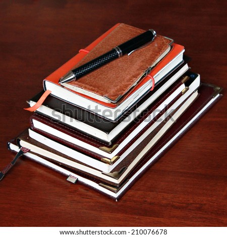 Stack of notebook with pen on the top