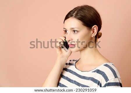 Young woman on cell phone, Portrait of beautiful young woman wearing striped t-shirt speaking on mobile phone