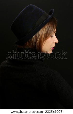 Beautiful woman in hat, Portrait of the young woman with a hat on the black background. Studio shot.