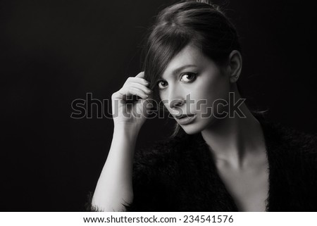 Black and white studio portrait , Portrait of beautiful woman in fluffy sweater on the black background