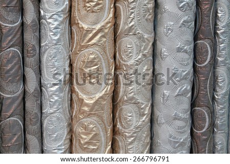 A variety of different bolts of brocade fabric, Colored brocade fabric in a traditional indonesian bazaar
