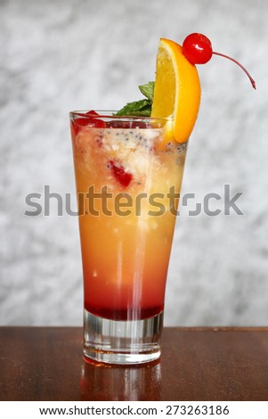 Mixed fruits mint cocktail in a glass\
Orange red non alcoholic cocktail with ice cubes