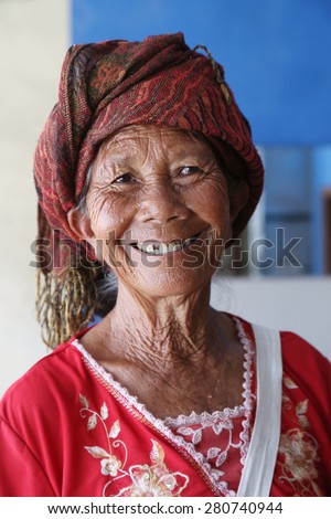 Elderly balinese woman, Ubud, Bali - April 23, 2015: An elderly wrinkled Balinese woman who sells handmade fans on the street, original skin texture, unedited photo.