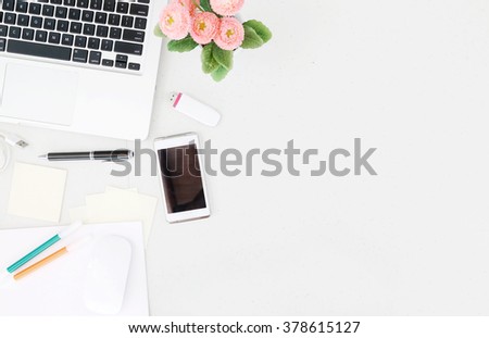 Office desk table with laptop, office supplies and flower pot. Top view with copy space.