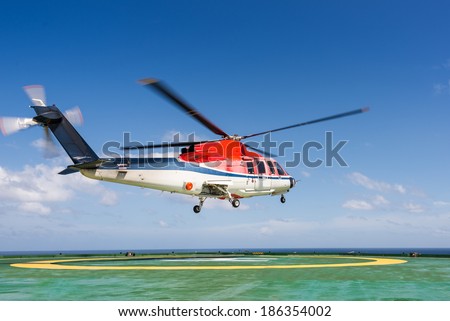Helicopter taking off from jack up oil rig with blue sky