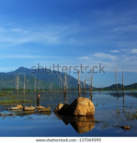 Scenic view of  with reflections of the blue sky and clouds, rocks in the water of Thailand