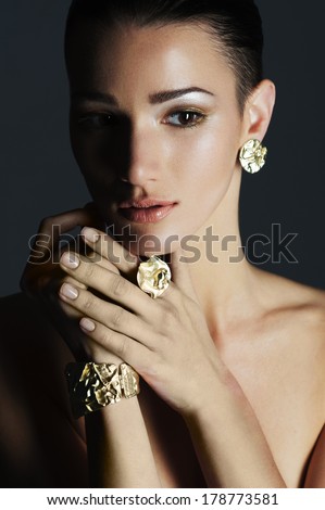 portrait of the beautiful fashion woman with black and gold makeup. Gold jewerly. expensive and luxurious