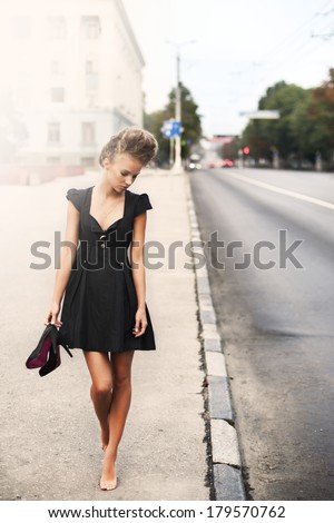 young sexy fashion woman in a little black dress indoor. morning and road