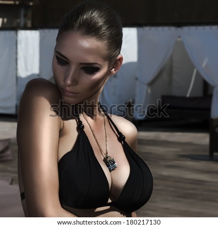 attractive young sexy and beautiful woman in black bikini by the pool. rock style