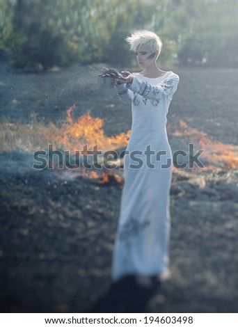 unusual woman in national dress on background of the earth and fire