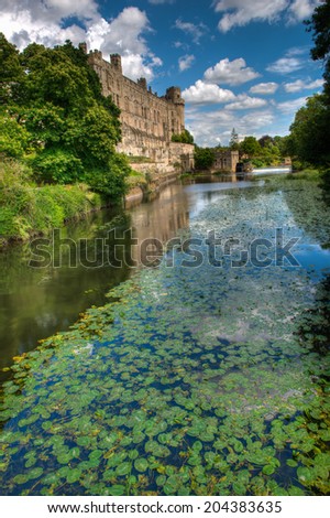 Warwick Castle and the river Avon on a bright and sunny summer day