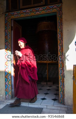 DHARAMSALA - DECEMBER 18: A Tibetan monk in prayer after spinning the prayer wheel on December 18, 2009 in Dharamsala, India. Dharamsala is the current home of the Tibetan government in exile.