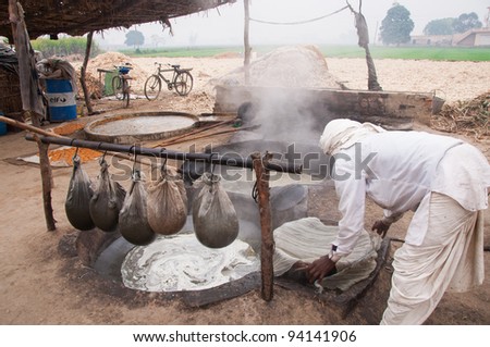 JASSO MAJARA - DECEMBER 20: An unidentified worker makes sugar out of sugarcane on December 20, 2009 in Jasso Majara, India. India is the world\'s second largest producer of sugar out of sugarcane production.
