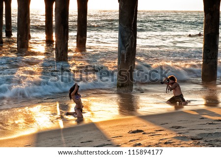 LOS ANGELES, USA - SEPTEMBER 24:  Model photography below Manhattan Beach Pier at sunset on September 24, 2012 in Los Angeles. The pier is a state historic landmark and has featured in several movies.