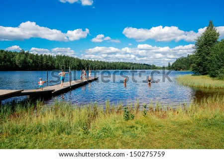 NORRKOPING, SWEDEN - AUGUST 4:  People enjoy a sunny day by lake Sorsjon in Norrkoping on August 4, 2013. Going to a lake for a swim is a typical leisure activity in Sweden at summertime.